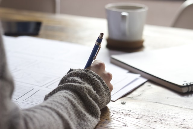 Preparing an application with notes beside a laptop